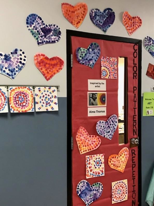 Photo of a classroom door decorated in multicolored hearts made of squares of paper in the style of Alma Thomas.